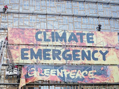 Des militants de Greenpeace évacués par des pompiers après avoir déployé une bannière sur le bâtiment du conseil européen à Bruxelles le 12 décembre 2019 - Kenzo TRIBOUILLARD [AFP/Archives]